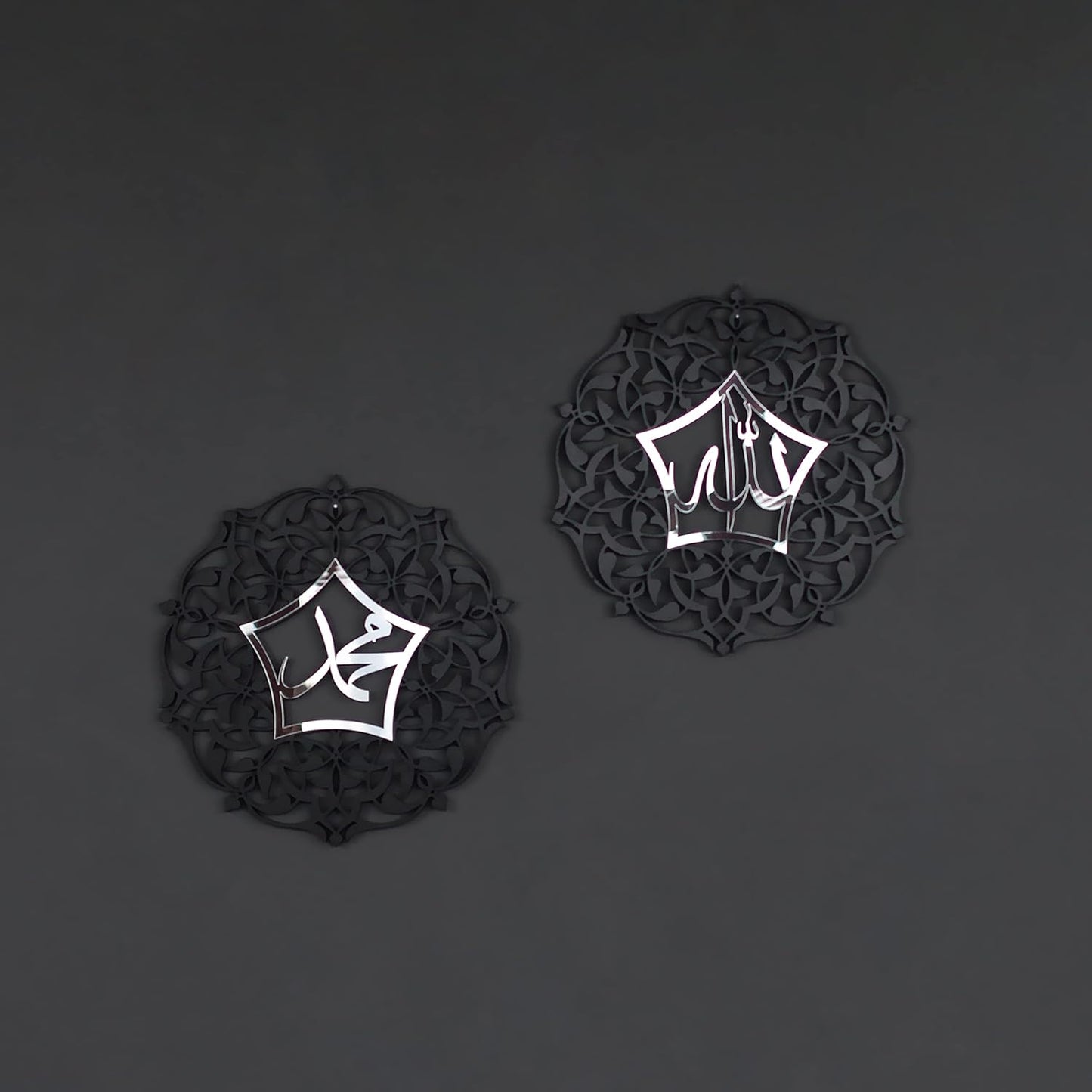 Two black decorative items with white geometric patterns on a dark gray background