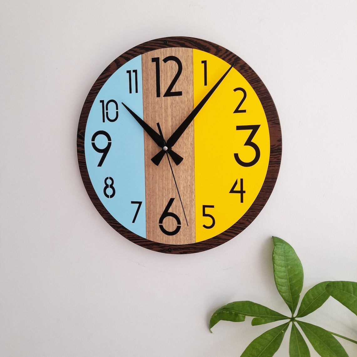 Colorful wall clock with wooden and painted sections on a white background