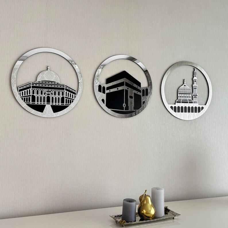 A set of three framed wall art pieces featuring representations of the Al Aqsa Mosque, Kaaba, and Masjid An-Nabawi, in gold and silver colors.