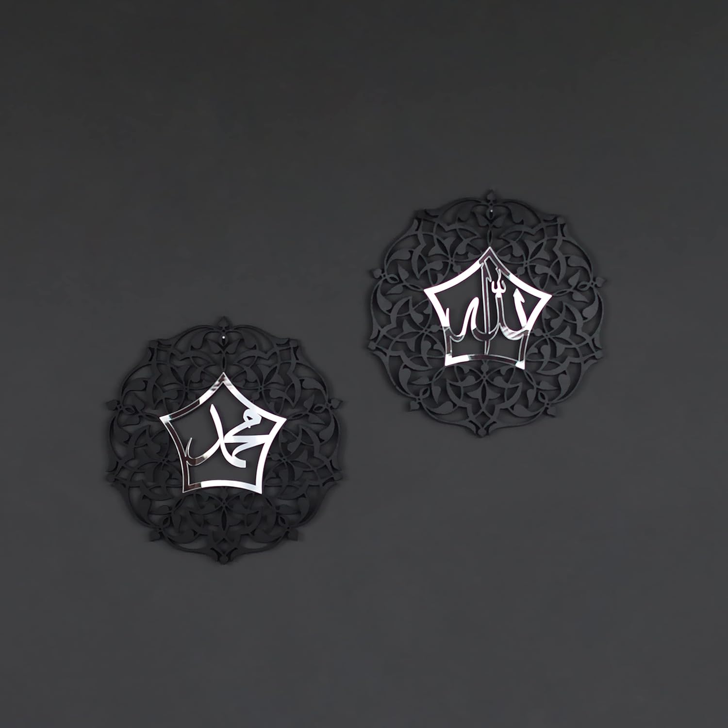 Two black decorative items with white geometric patterns on a dark gray background