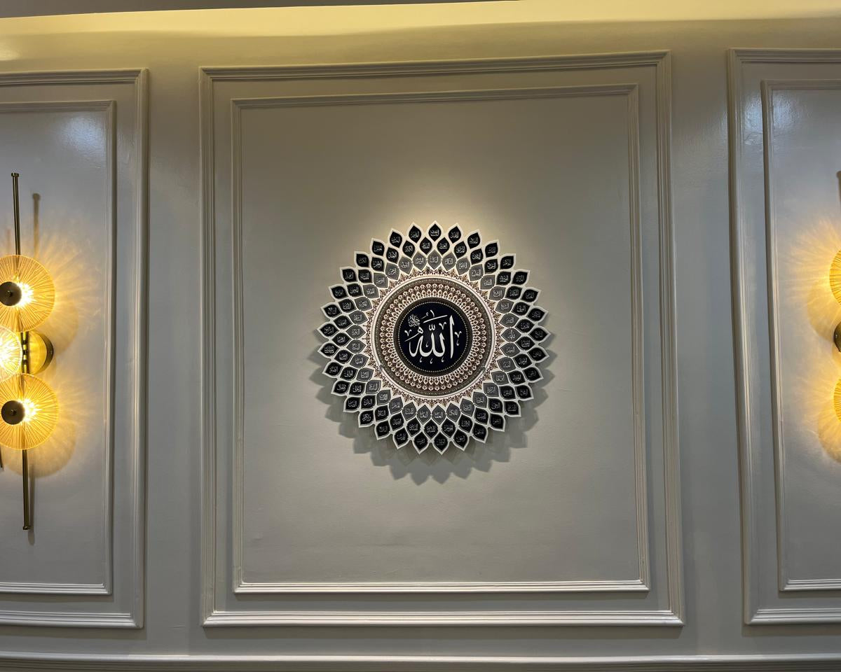 Decorative wall art with a central circular design and Arabic text, flanked by two wall lights on a gray panel.
