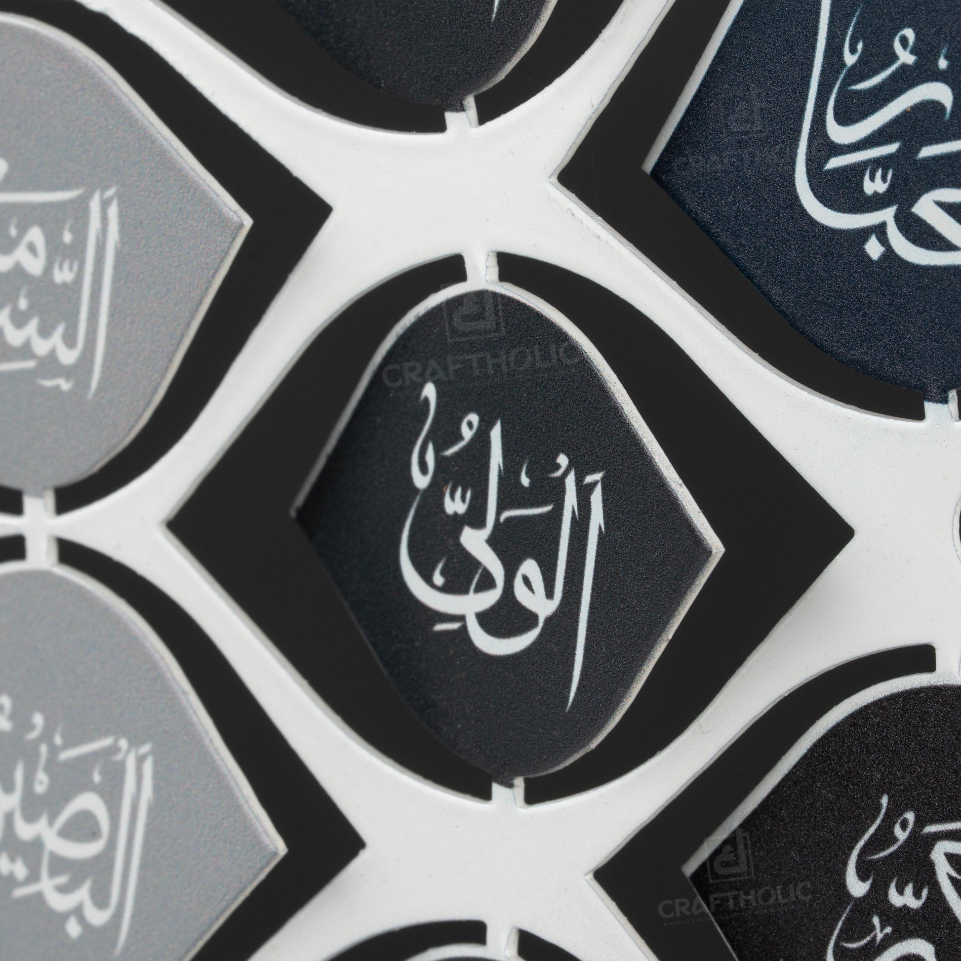 A 3D metal wall art featuring intricate calligraphy with the 99 names of Allah, predominantly in gray tones with decorative elements in gold.