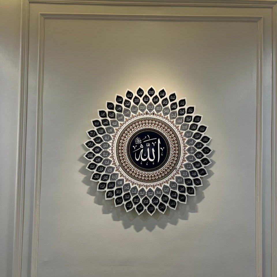 A 3D metal wall art featuring intricate calligraphy with the 99 names of Allah, predominantly in gray tones with decorative elements in gold.