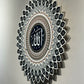 Decorative wall art with 'Allah' text in a circular pattern on a plain background