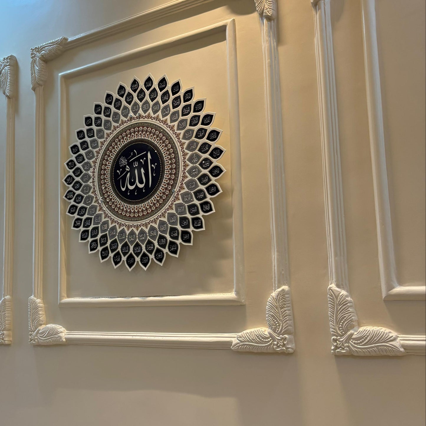 Decorative wall art with intricate designs on a beige wall.