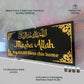 Decorative wall art with 'Masha Allah' text on a black background with gold accents.